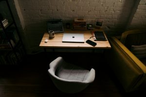 a laptop computer sitting on top of a wooden desk